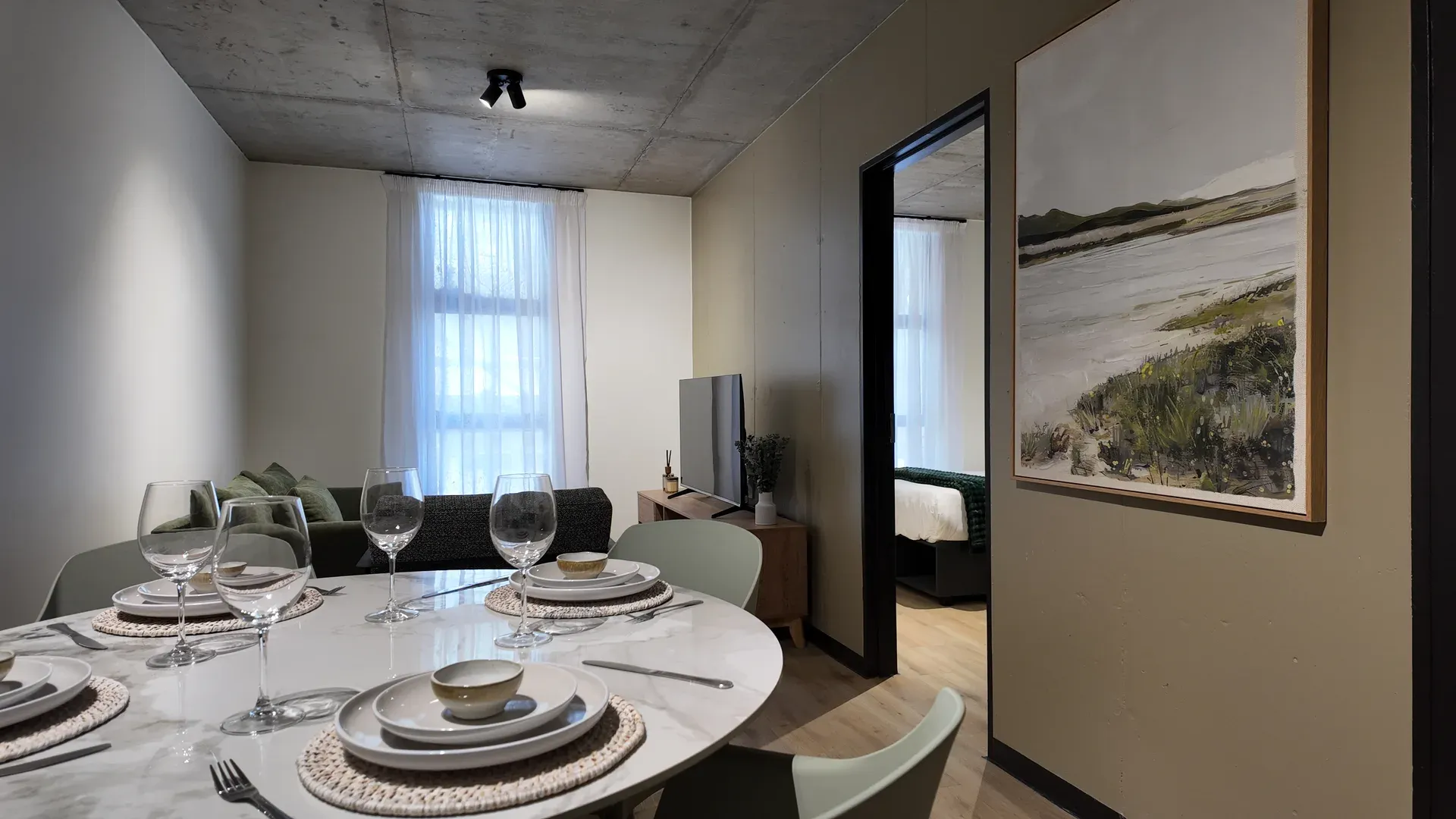 Dining and living area of a Jetty Quarter apartment, with the bedroom beyond