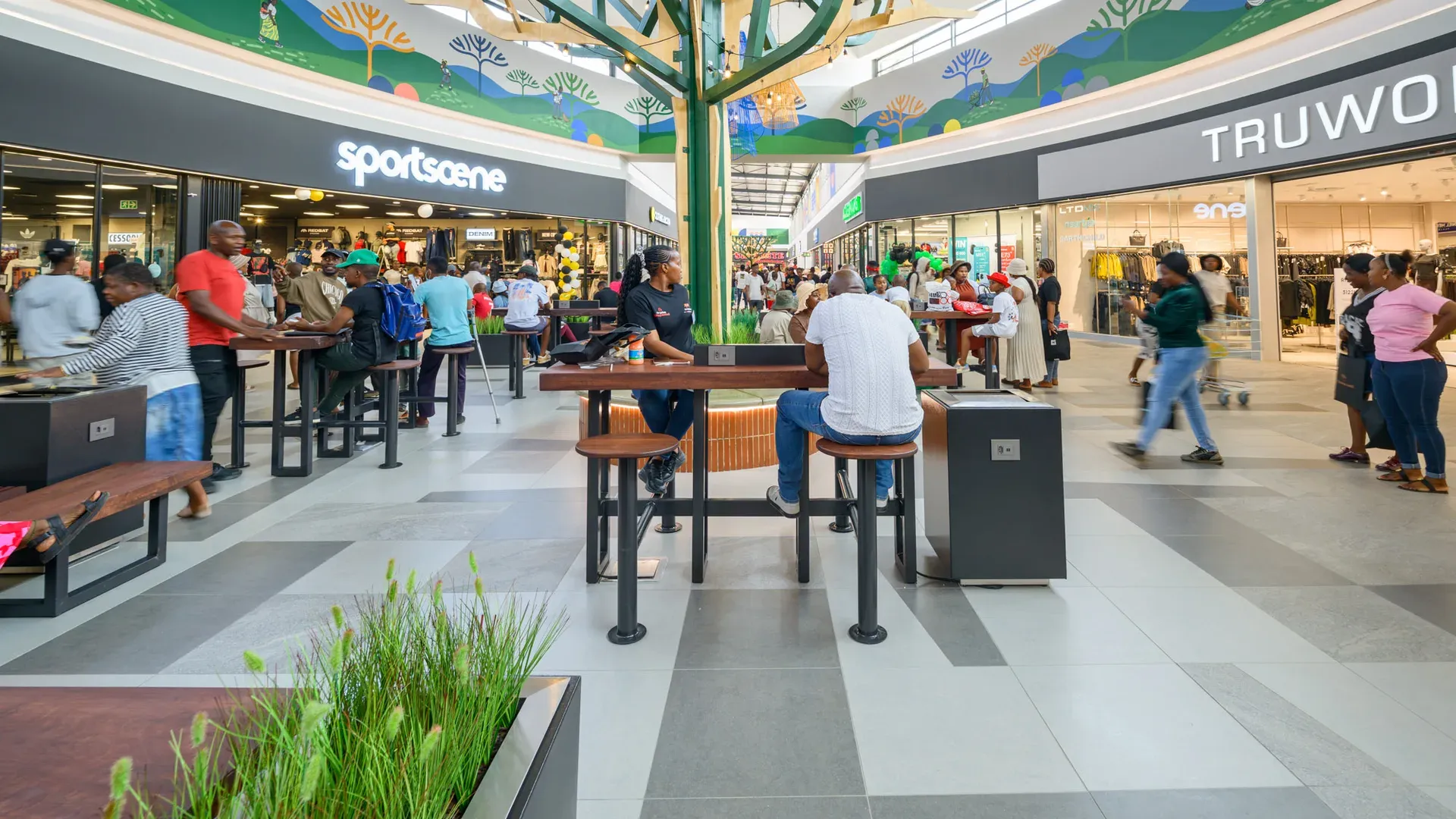 The Malekane Mall centre court, with seating beneath the tree and the mural above